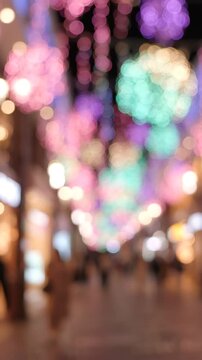A Vibrant Night Scene Filled with Colorful Bokeh Lights and Blurred Figures in a Festively Decorated Streetscape, Perfect for Creating a Magical Atmosphere