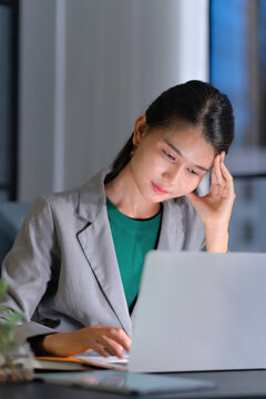 tired asian businesswoman stressful at workplace, late night