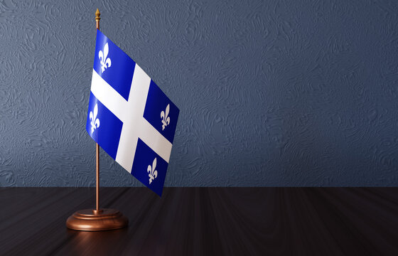 Flag of Quebec - Province of Canada - on the desk. Quebec Day. Saint-Jean-Baptiste Day