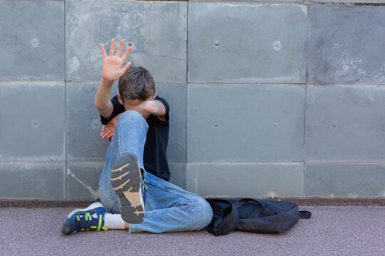 Lonely teenager showing a stop sign sitting on the floor