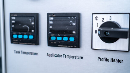 Industrial control panel displaying temperature controllers and manual selection dial © Marcin