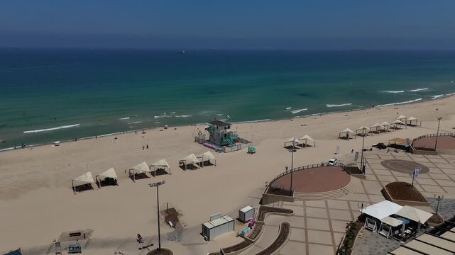 4K Slow Motion Continuation Orbit Drone Around Lifeguard Tower, HaKeshet Beach Ashdod Israel, Sea and City Skyline View
