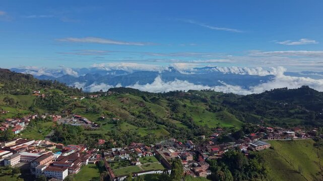 Aerial view of Jerico town nestled in lush green hills with distant mountain clouds