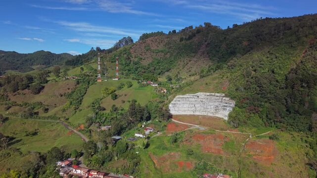 Aerial view reveals Jerico town rooftops nestled below lush green hills and mountains