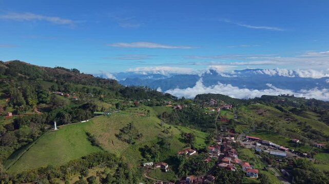 Aerial view of Jerico town nestled in lush green hills with distant mountain clouds