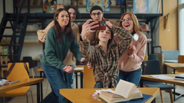 Group of friends taking a selfie in a library during afternoon study session and enjoying their time together with smiles and laughter