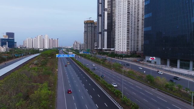 Jawaharlal Nehru Outer Ring Road with moving vehicles, sign boards and skyscraper at financial district, nanakramguda, gachibowli, hyderabad, telangana, india. day time, crane shot, drone shot, 4k.