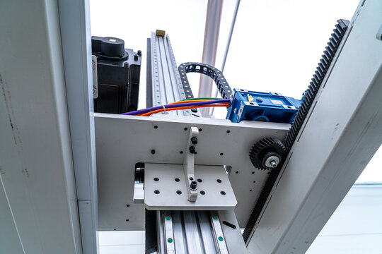 Automated machinery showing linear guide, rack and pinion, motor, and cables