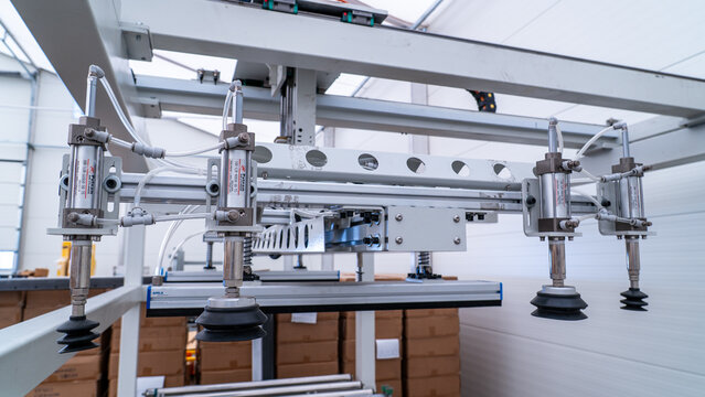 Automated robotic arm using suction cups for material handling in warehouse logistics
