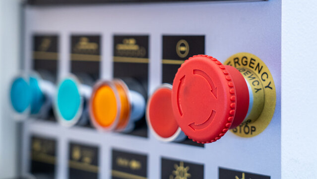 Machine control panel featuring a red emergency stop button for industrial safety