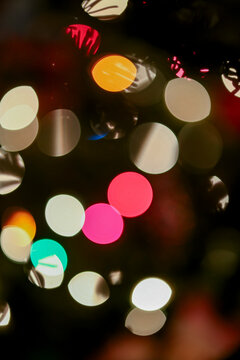 Colorful blurred lights creating a festive bokeh effect in various shapes and hues.