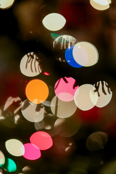 Colorful abstract bokeh lights creating a festive and vibrant atmosphere in darkness.
