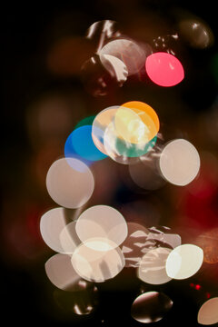 Colorful bokeh lights on a dark background creating an abstract festive effect.