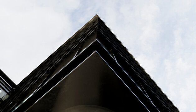 Abstract view of a modern building's sharp corner against the cloudy sky. Illustration, rendering