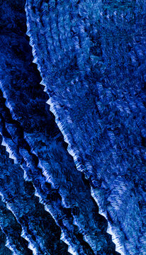 Abstract pattern of textured blue layers resembling ocean waves or fabric folds