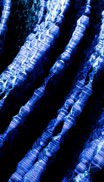 Abstract blue and white flowing lines creating a wave-like pattern on a dark background.