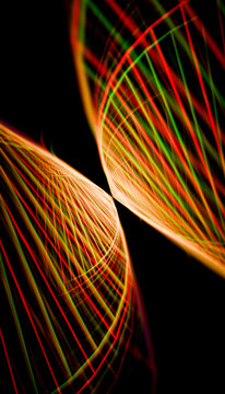 Intersecting vibrant light trails with red and green hues in a dynamic pattern on black.