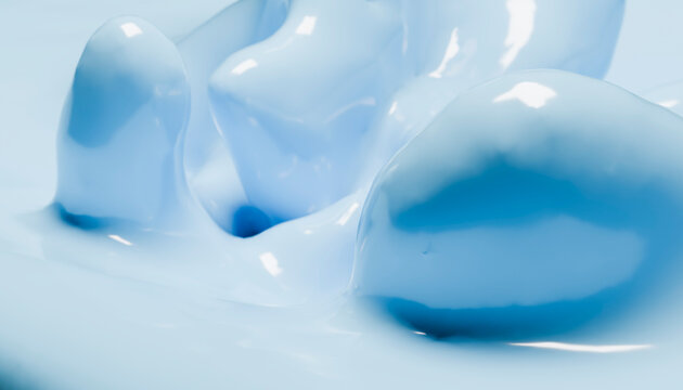 Smooth, glossy blue liquid creating abstract shapes and reflections