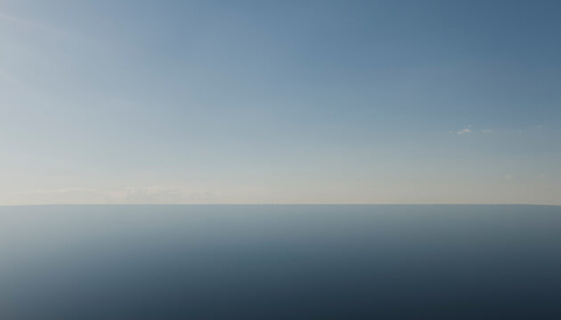Calm ocean with clear blue sky extending to the horizon under bright daylight.