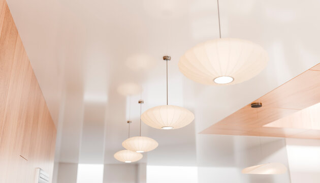 Modern ceiling with a row of white pendant lights in a minimalist interior.