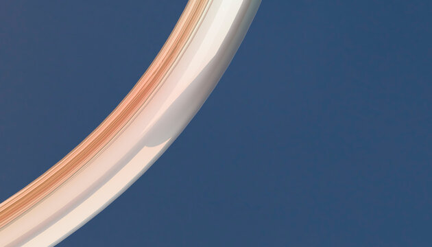 A curved metallic arch against a clear blue sky with a gradient of beige and white hues.
