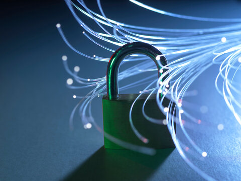 Padlock with glowing fiber optic strands representing data security and internet.