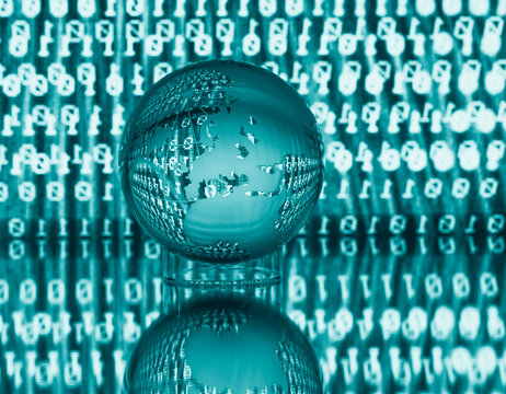 Transparent globe on reflective surface with binary code backdrop in teal hue.