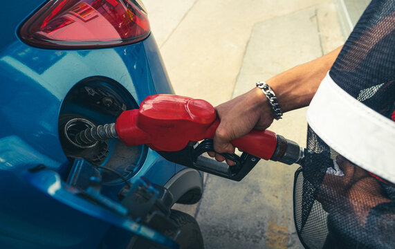 Car fueling at gas station. Refuel fill up with petrol gasoline. Petrol pump filling fuel nozzle in fuel tank of car at gas station. Petrol industry and service. Petrol price and oil crisis concept.