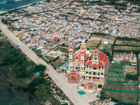 Aerial view of colorful buildings and a large temple in a coastal landscape. Ly Son island, Vietnam