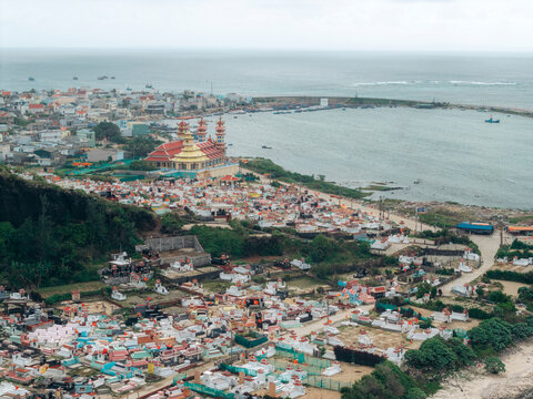 Aerial view of a coastal city with a colorful cemetery near the waterfront and distant buildings. Ly Son island, Vietnam