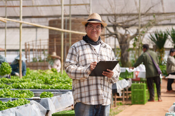 Obraz premium An organic vegetable farm owner checks his vegetables for sale to a global business.