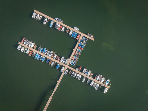 Aerial view of boats docked on a lake, forming a T-shape on the water.