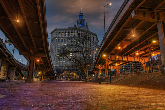 Underpass view of majestic skyscraper with illuminated lights during twilight. New York, USA