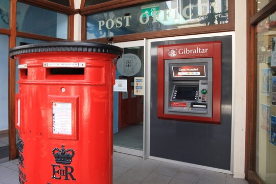 A typical red postbox and a cash machine outside a post office in the British Overseas Territory of Gibraltar