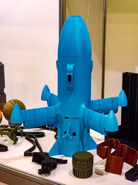 3D Printed Blue Plastic Rocket Missile Model Prototype with Other Technical Components on Exhibition Table