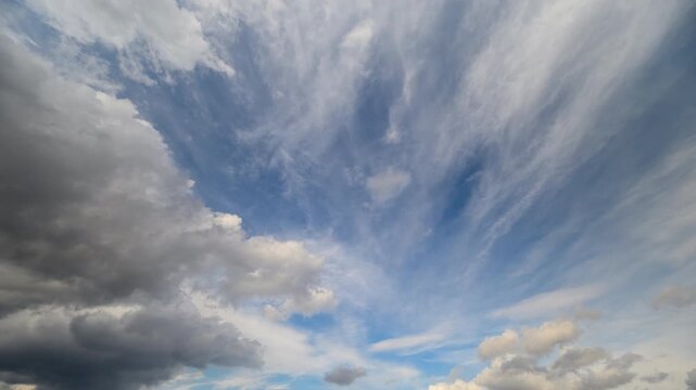 Timelapse of contrasting clouds racing in different directions overhead. Vivid atmospheric scene with layered clouds swift moving in opposing paths above turbulent weather