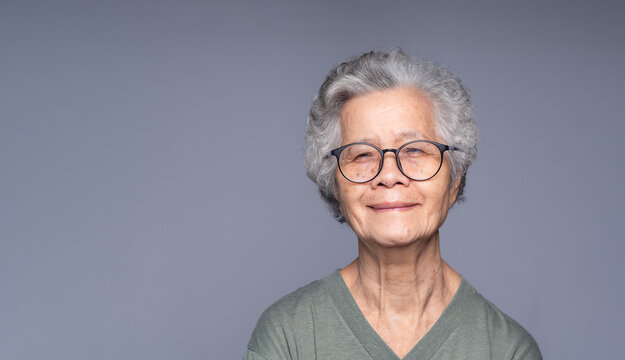 Smiling senior woman portrait on gray background