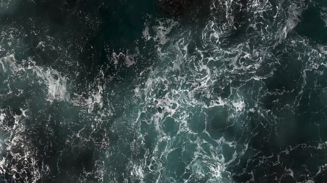 Aerial view of Ben Buckler rock at North Bondi with waves breaking on the coast on a beautiful sunny day. Camera orbits in CCW direction.