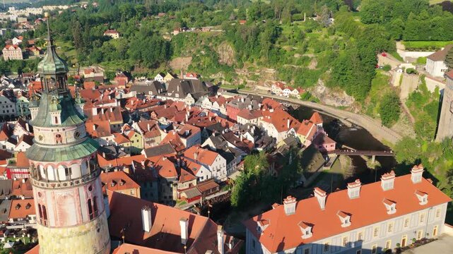 Cinematic aerial view of Cesky Krumlov historic town center at sunrise. Drone shot of beautiful medieval architecture, Vltava river, castle tower, and red roofs. Czechia, UNESCO World Heritage Site