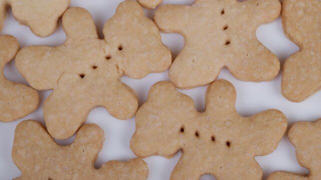 Cookies with bear shape. Decorated shortbread biscuits arranged beautifully. Minimalist flatlay of scattered shortbread cookies with perforated details in natural lighting