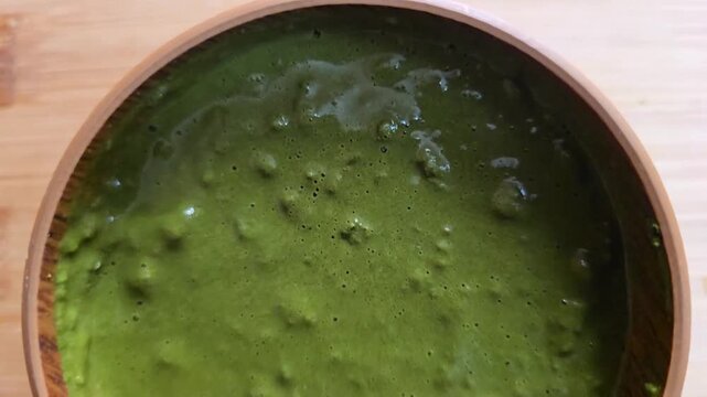 Top view of a freshly mixed, thick Sidr (Ziziphus spina-christi) herbal paste in a wooden bowl. Perfect for showcasing natural cosmetic texture and organic skincare preparation process.