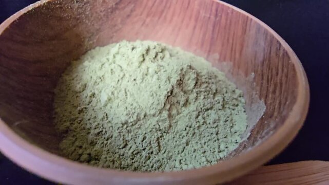 Fine powder of Ziziphus spina-christi leaves, also known as Sidr, in a wooden bowl.