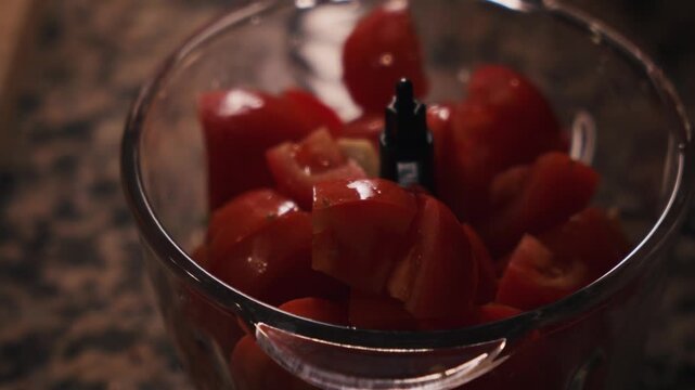 Chopped tomatoes in food processor for traditional Spanish gazpacho preparation. Spanish cuisine and healthy summer food.