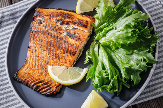 Salmon asado grilled fish with salad on table