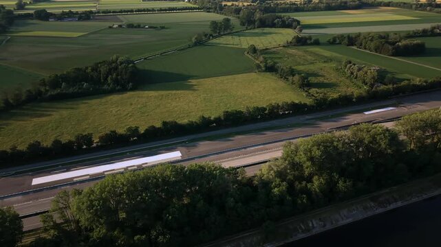 High angle drone footage of a vehicle testing complex in Germany showing structured proving circuits and research facilities bordered by green farm fields