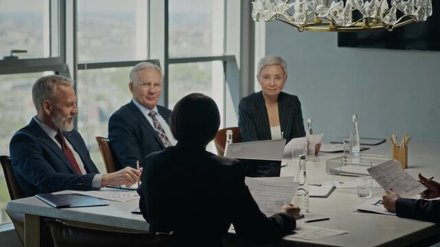 Pan shot of diverse business executives holding oil industry meeting in modern boardroom, reviewing documents. Ideal for corporate communication and energy sector marketing campaigns
