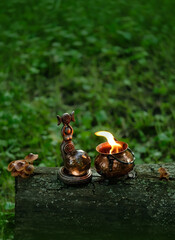 Obraz premium wiccan Goddess figurine with crystal ball and burning witch cauldron in forest, dark natural background. esoteric spiritual practice. magic ritual, witchcraft. mystery, fairy tale atmosphere
