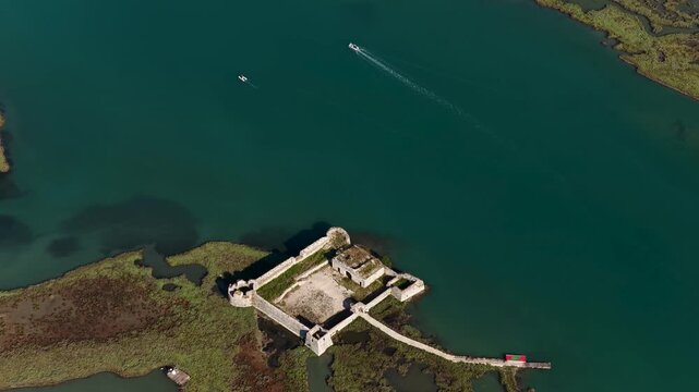Aerial view of Ali Pasha Castle surrounded by turquoise water and green marshland in Mahala, Qarku i Vlores, Albania.
