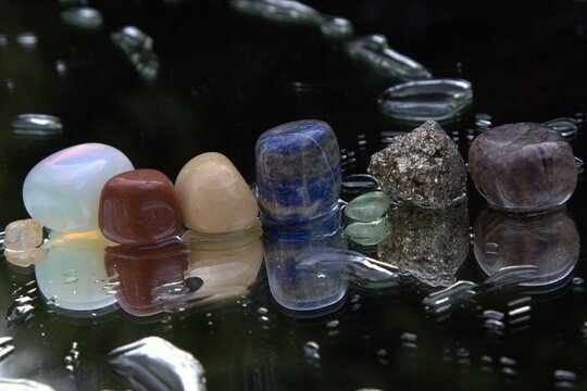 Colourful Gemstones on Reflective Background with Water Droplets