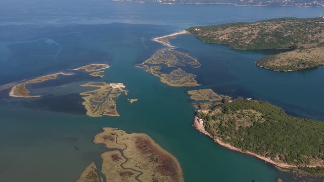 Aerial view of Ali Pasha Castle surrounded by coastal wetlands and lush green hills in Mahala, Qarku i Vlores, Albania.
